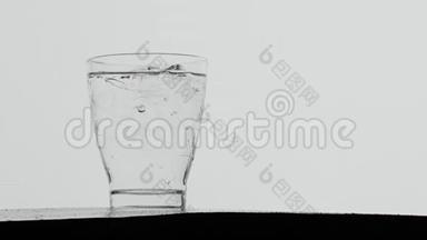 冰块滴在一杯起泡的水中，